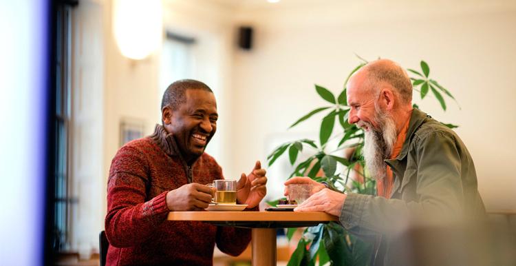 Two men sitting at a table laughing