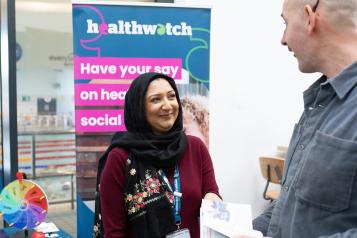 Asian woman and white man at a Healthwatch stall