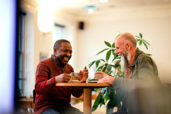 Two men sitting at a table laughing