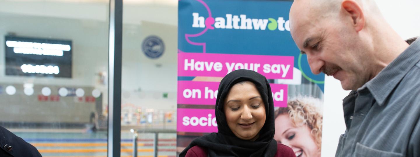 Healthwatch Stall With Asian Muslim Woman and White Man